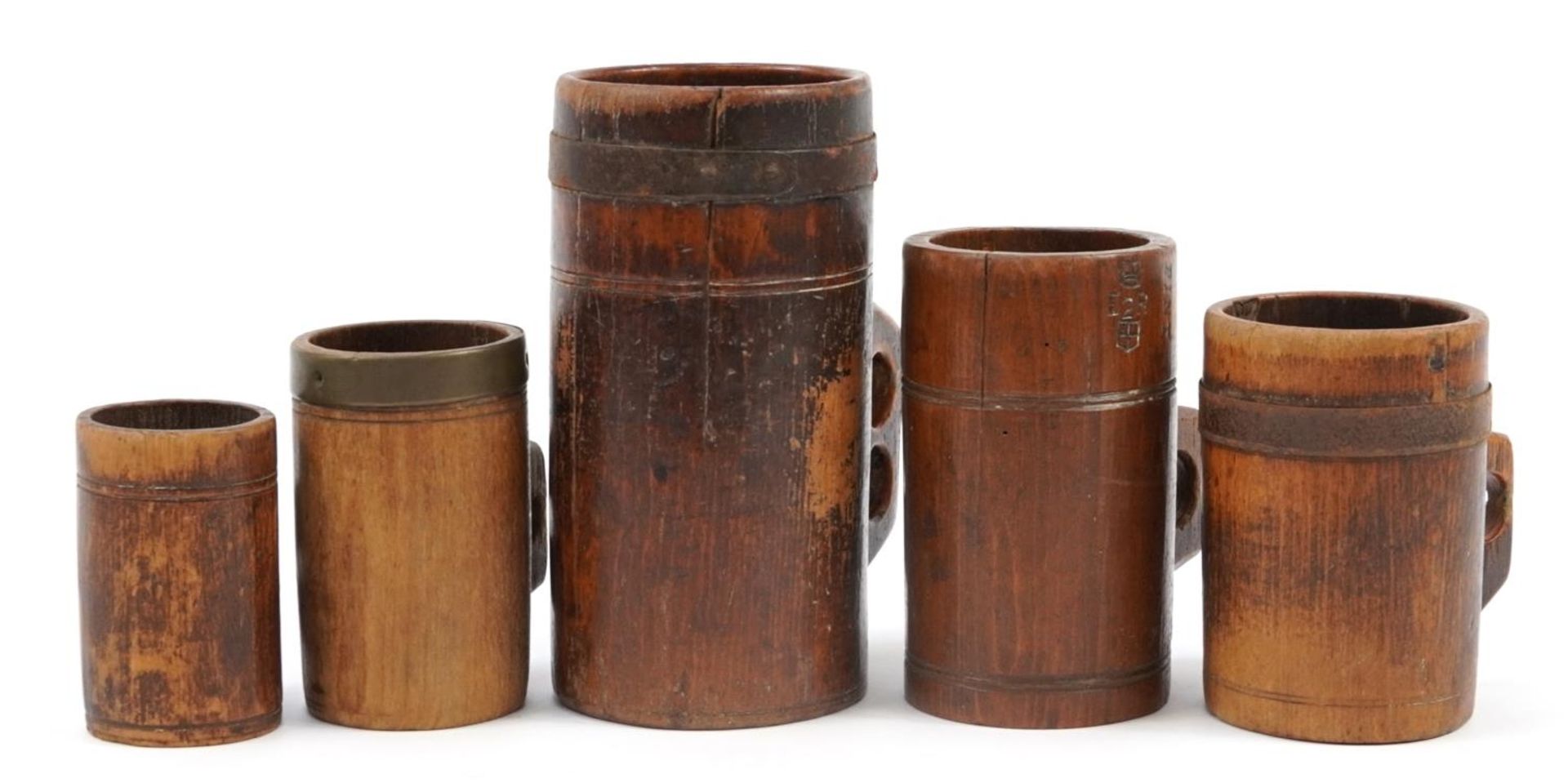 Five antique Tudor style treen tankards including three metal bound, various impressed marks, the