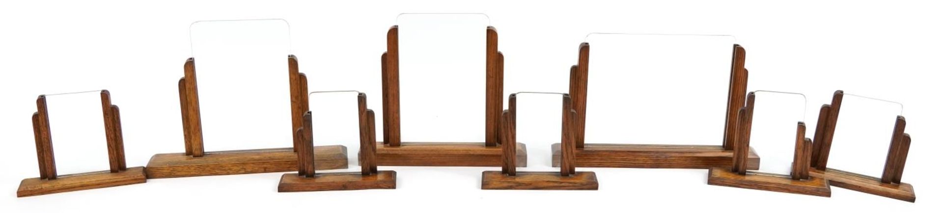 Eight Art Deco oak photo frames with glass inserts including two pairs, the largest 33.5cm wide