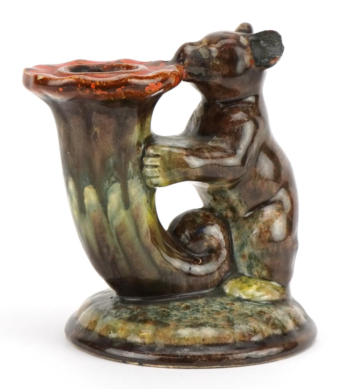 German Art Deco candlestick in the form of a bear holding a cornucopia having a mottled glaze,