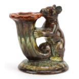 German Art Deco candlestick in the form of a bear holding a cornucopia having a mottled glaze,