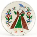 Turkish Ottoman Kutahya plate hand painted with a figure wearing traditional dress, 15cm in diameter