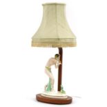 Art Deco walnut table lamp mounted with a Czechoslovakian porcelain figurine of a snake charmer, the
