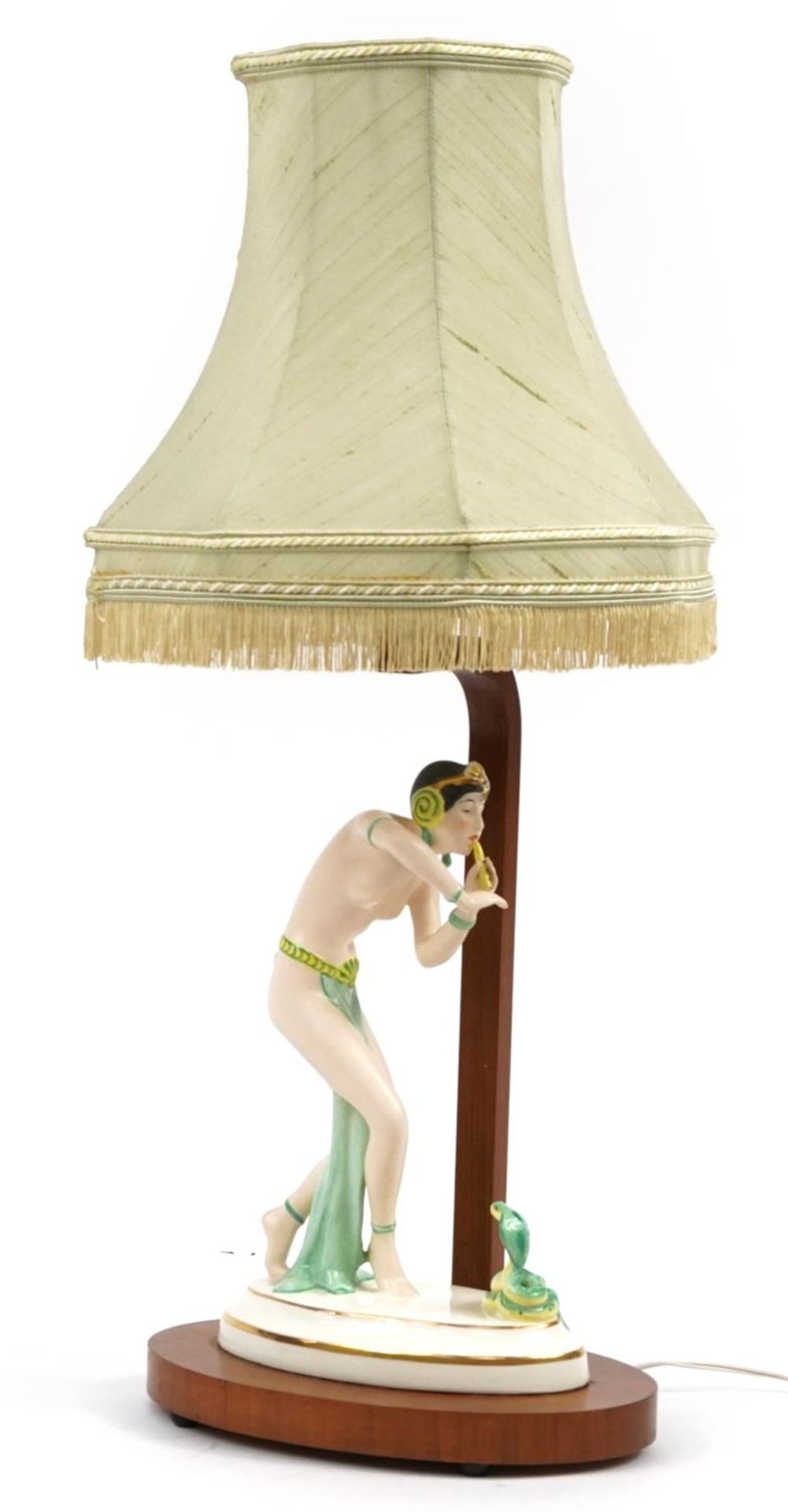 Art Deco walnut table lamp mounted with a Czechoslovakian porcelain figurine of a snake charmer, the