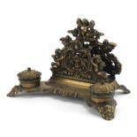 19th century style brass desk stand decorated with Putti with letter rack and pair of inkwells, 30cm