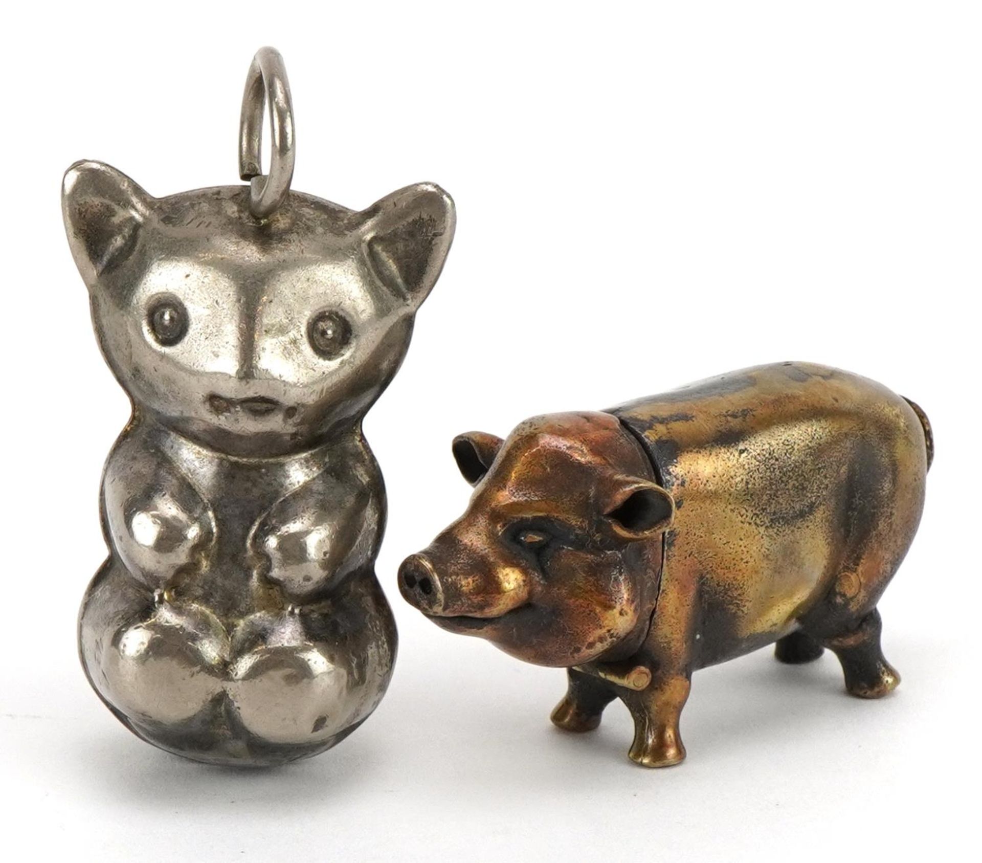 Novelty brass vesta case in the form of a pig and a silver plated baby's rattle in the form of a