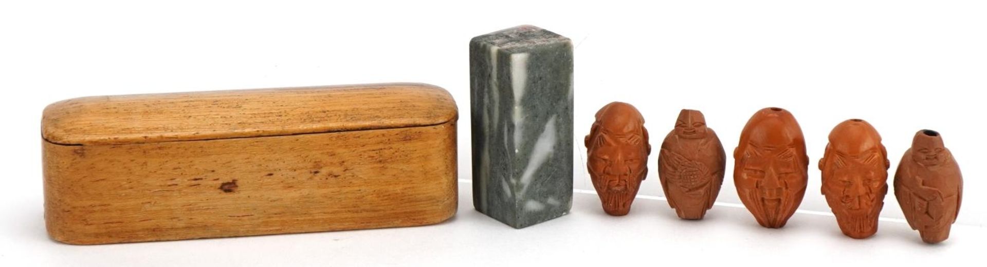 Five Chinese carved coquilla nuts and a hardstone desk seal with calligraphy, with hardwood case