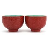 Pair of Chinese faux cinnabar lacquer porcelain footed bowls decorated in low relief with bats and