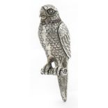 White metal model of a parrot perched on a branch with ruby set collar, 9.5cm high For further