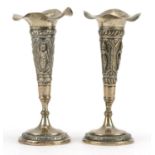 Pair of Anglo Indian white metal trumpet bud vases embossed with deities, 11.2cm high For further