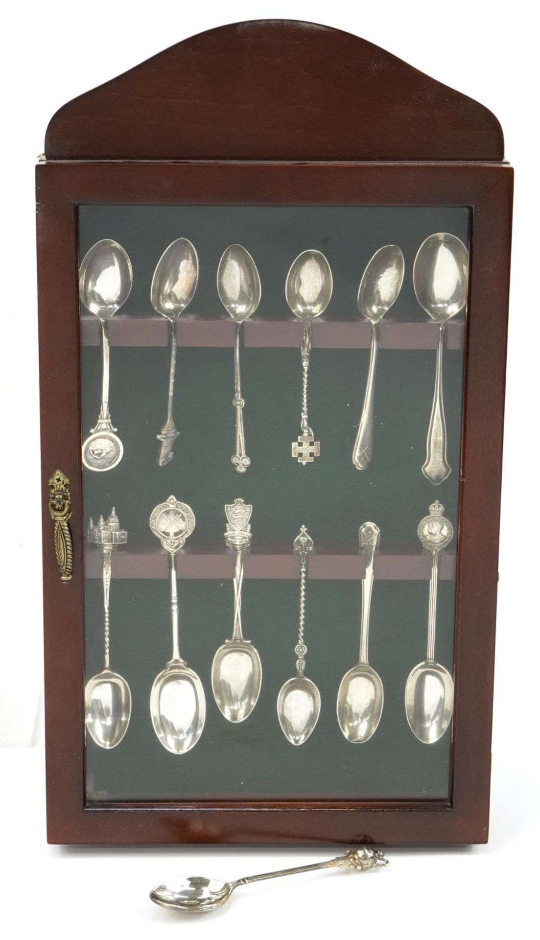 Thirteen silver sporting and souvenir teaspoons housed in a mahogany display case, the largest 12.