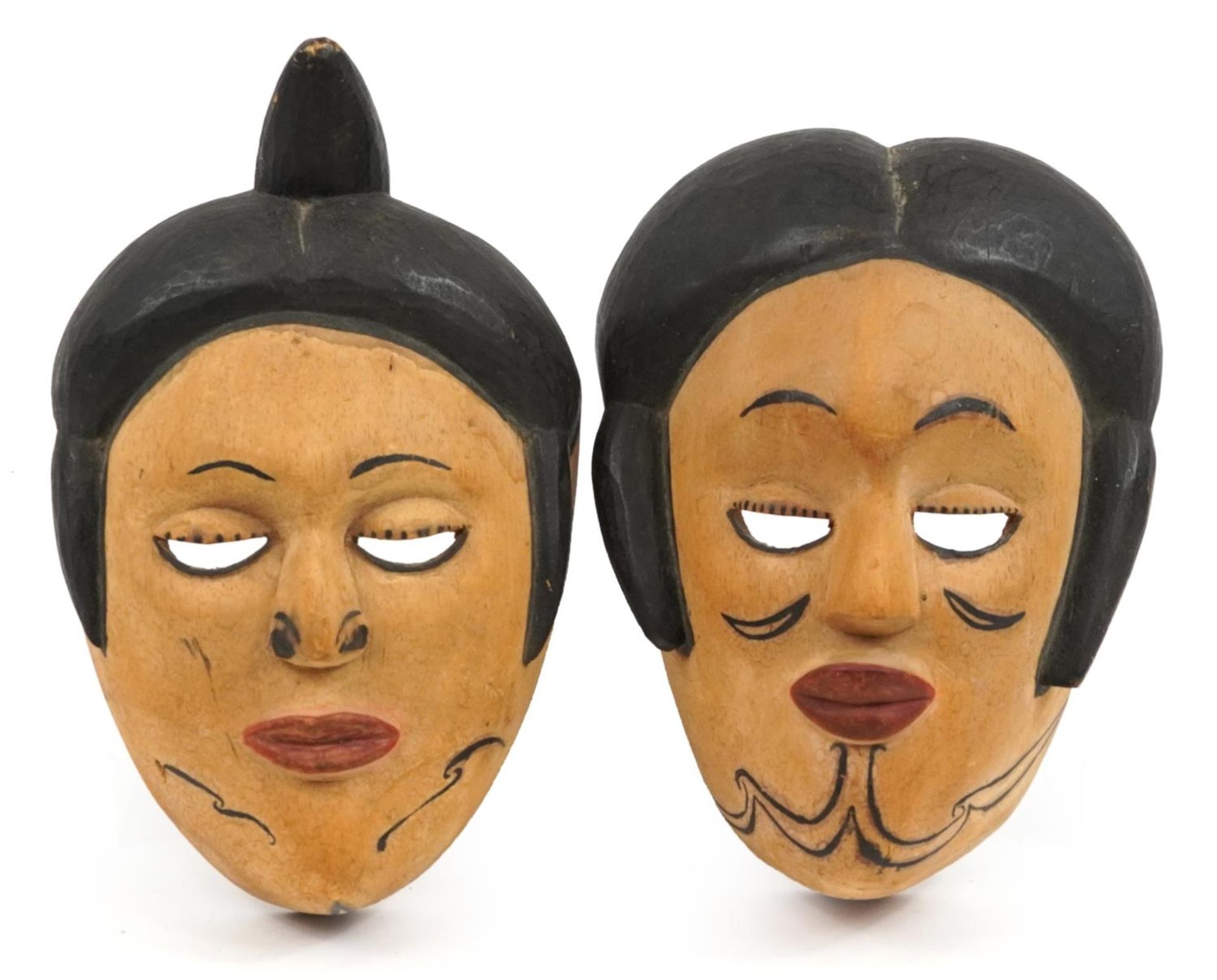Two early 20th century African tribal interest carved wood face masks from Nigeria, the largest 29cm