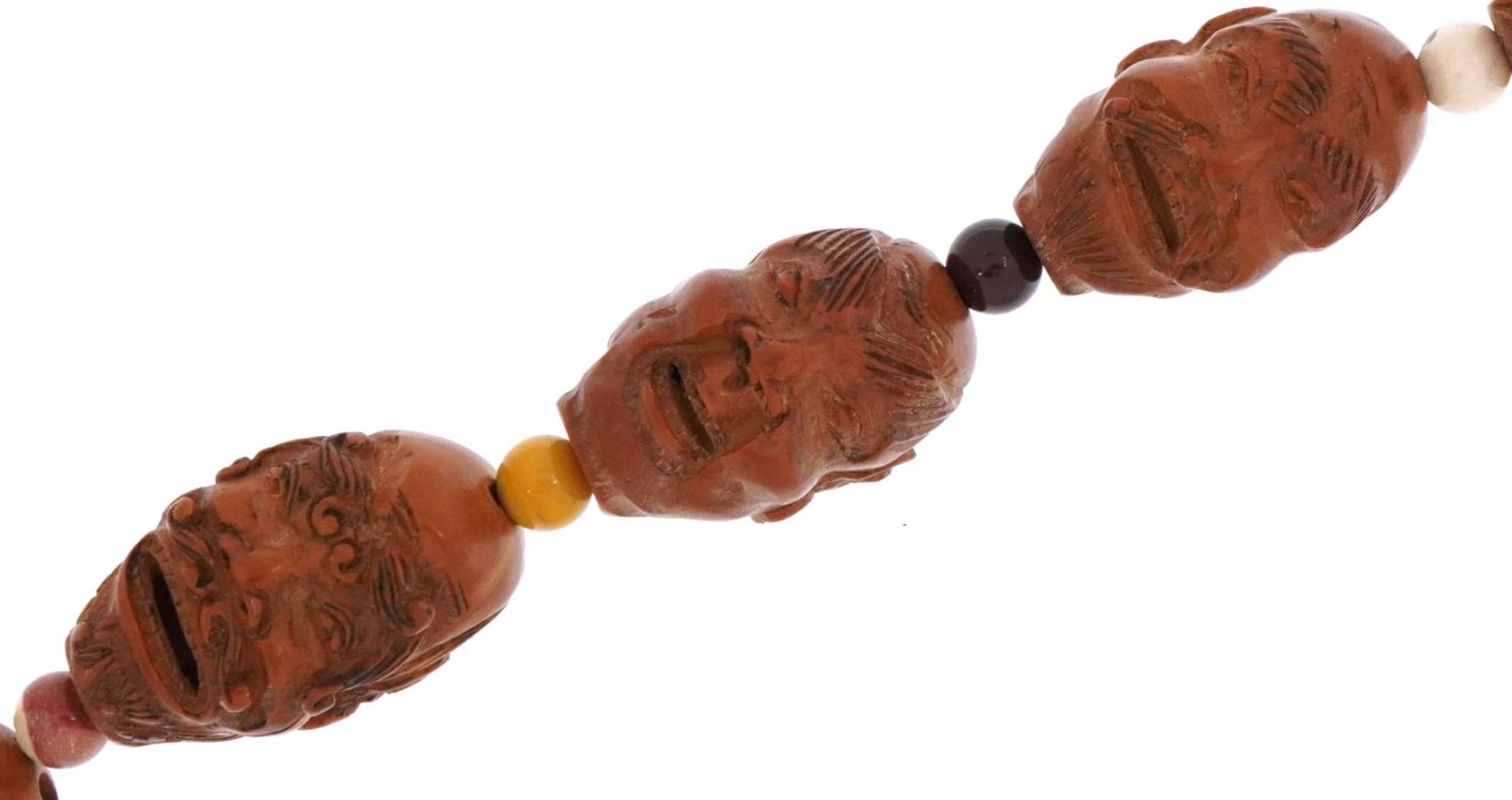 Chinese coquilla nut necklaces carved with faces of elders and Buddhas, 67cm in length For further