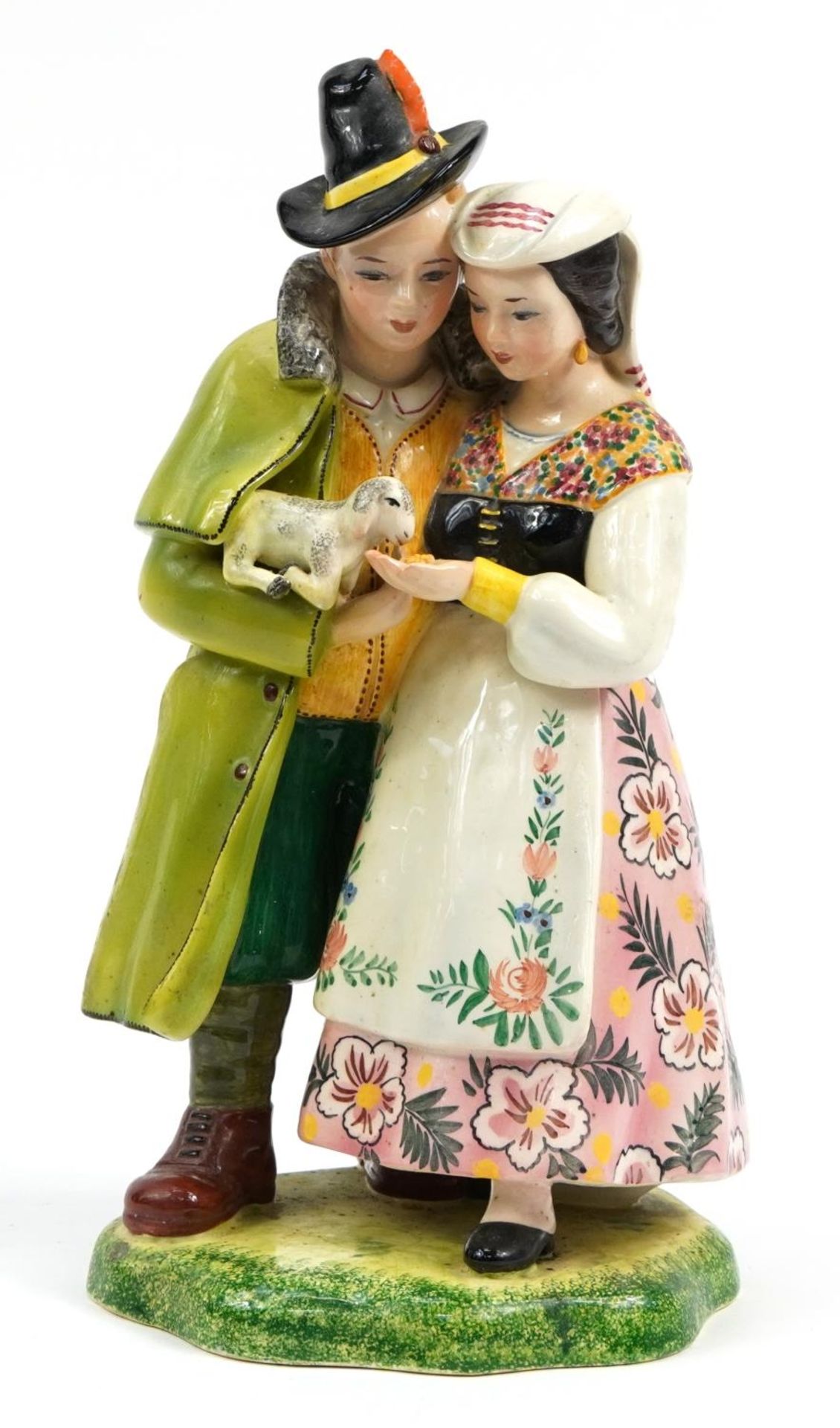 Large Italian faience glazed pottery figure group of two figures holding and feeding a lamb,