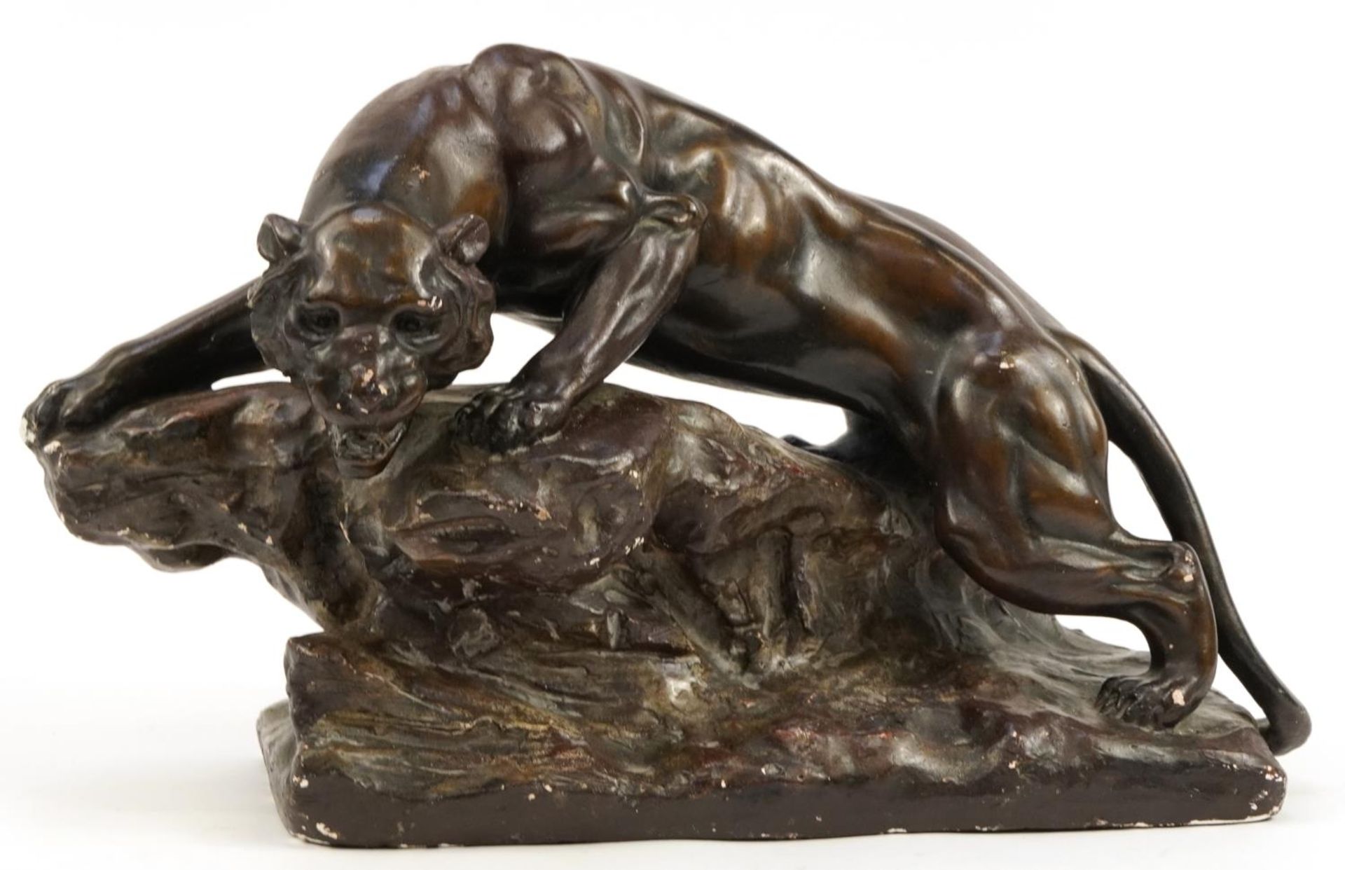 French Art Deco bronzed plaster sculpture of a lion on rock, signed Berce, 47cm in length For