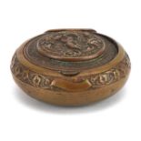 19th century circular brass snuff box with hinged lid, decorated in relief with Putti, 5cm in