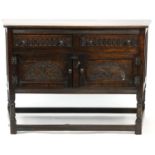 Carved oak linen fold style side cabinet with two frieze drawers above a pair of cupboard doors,