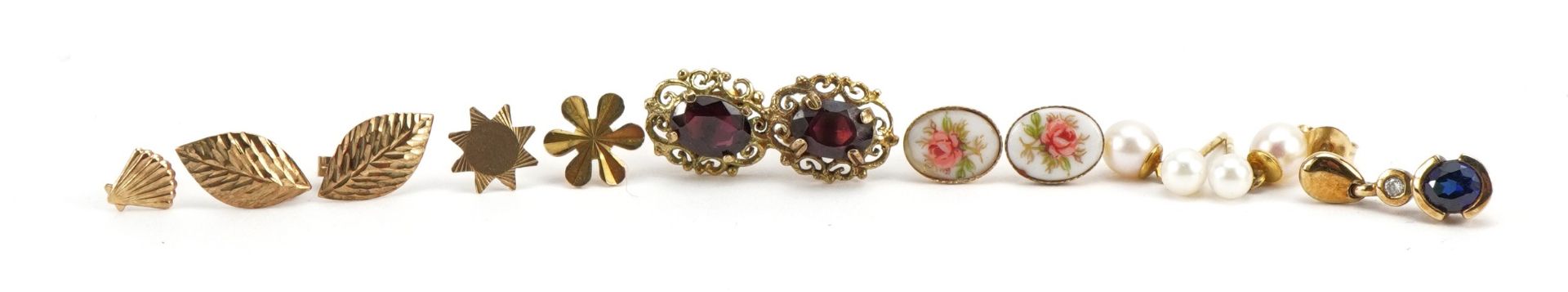 9ct gold and yellow metal earrings including a pair of garnet studs, pearl drops and one earring set