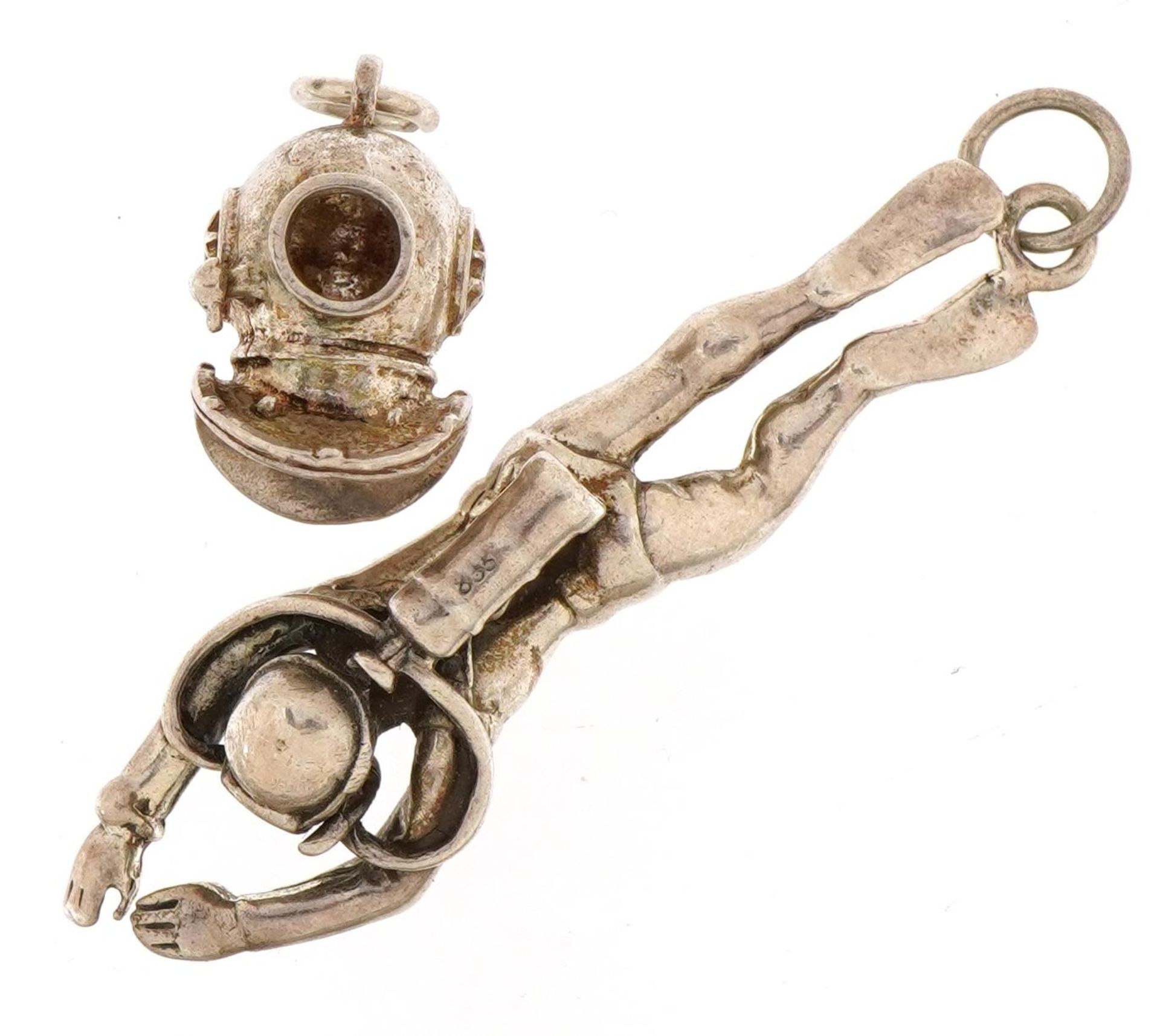 Two silver diving interest charms comprising diver and helmet, one marked 835, 4.5cm high, total