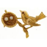 9ct gold bird and nest brooch with two pearl eggs and a red stone eye, 3.3cm wide, 5.0g : For