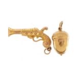 Two 9ct gold charms comprising acorn and pistol, the largest 2.6cm wide, total 1.7g : For further