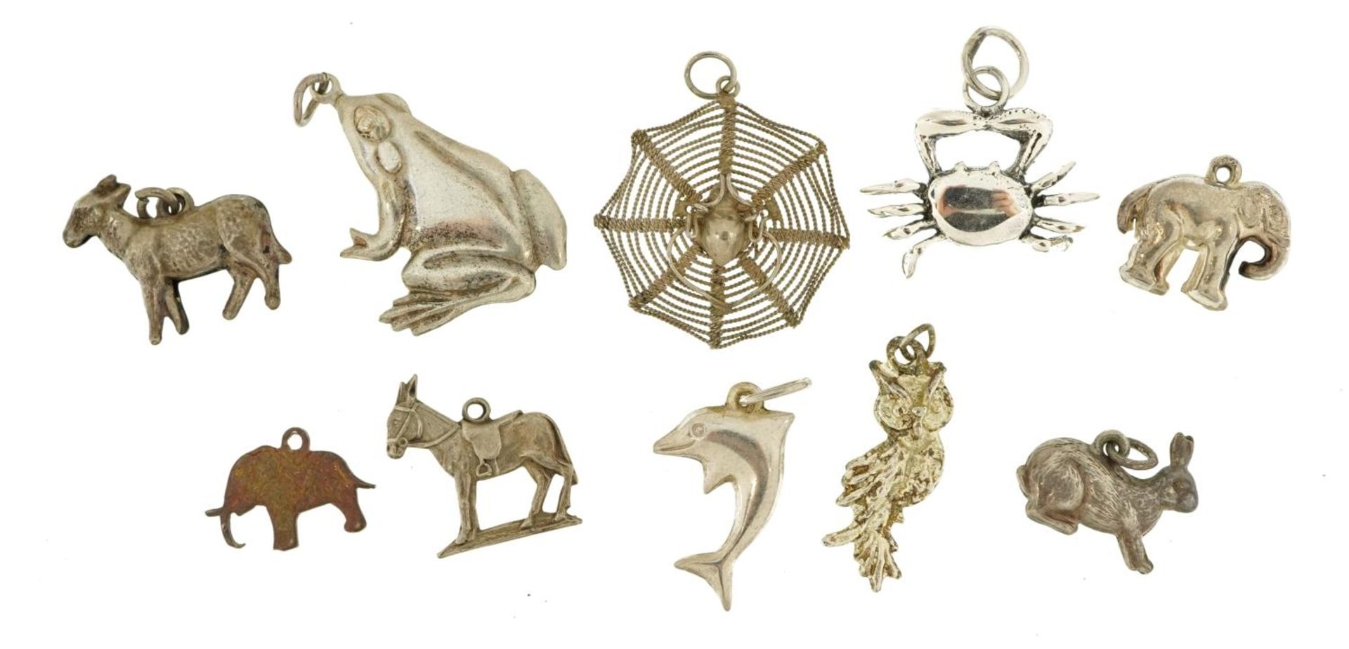 Ten silver and white metal charms and pendants including spider in a web, elephant, frog and hare,