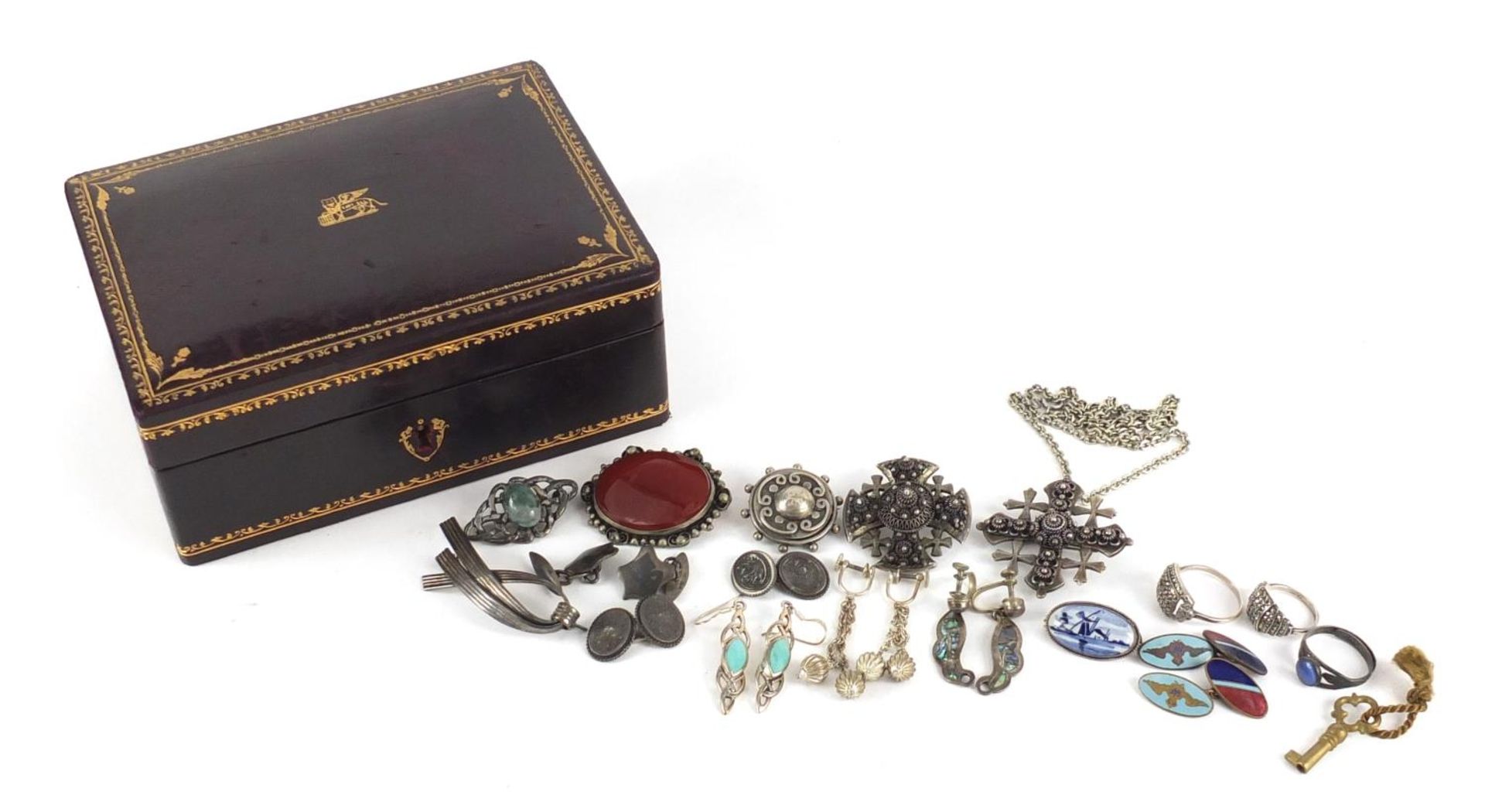 Silver and white metal jewellery housed in a Victorian tooled leather box, including brooches, rings