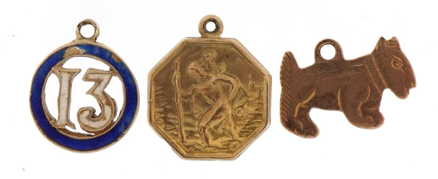 Three 9ct gold charms comprising enamelled number 13 and a St Christopher, the largest 1.5cm high,