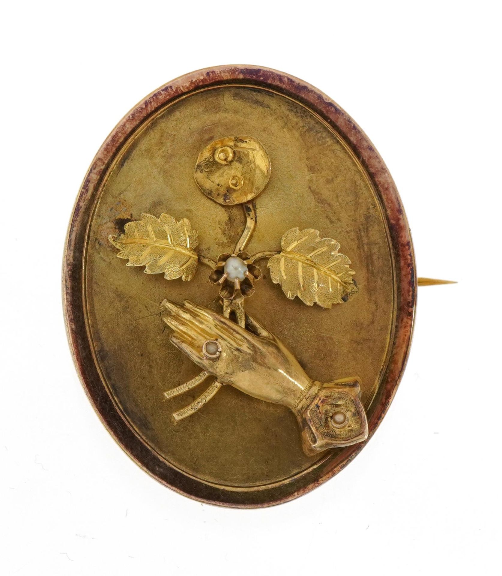 Victorian unmarked gold mourning locket decorated in relief with a female's hand holding flowers,