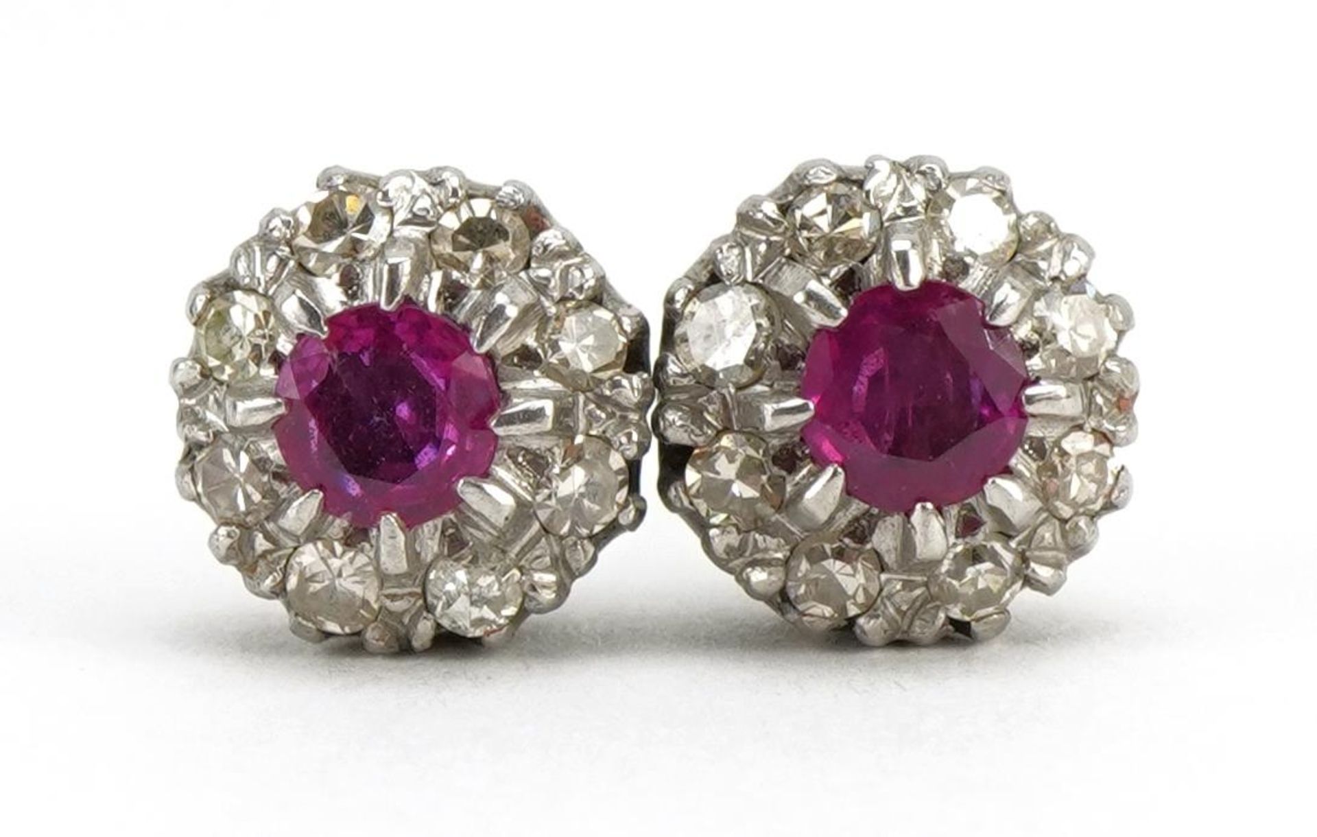 Pair of unmarked white gold ruby and diamond two tier cluster stud earrings, each ruby approximately
