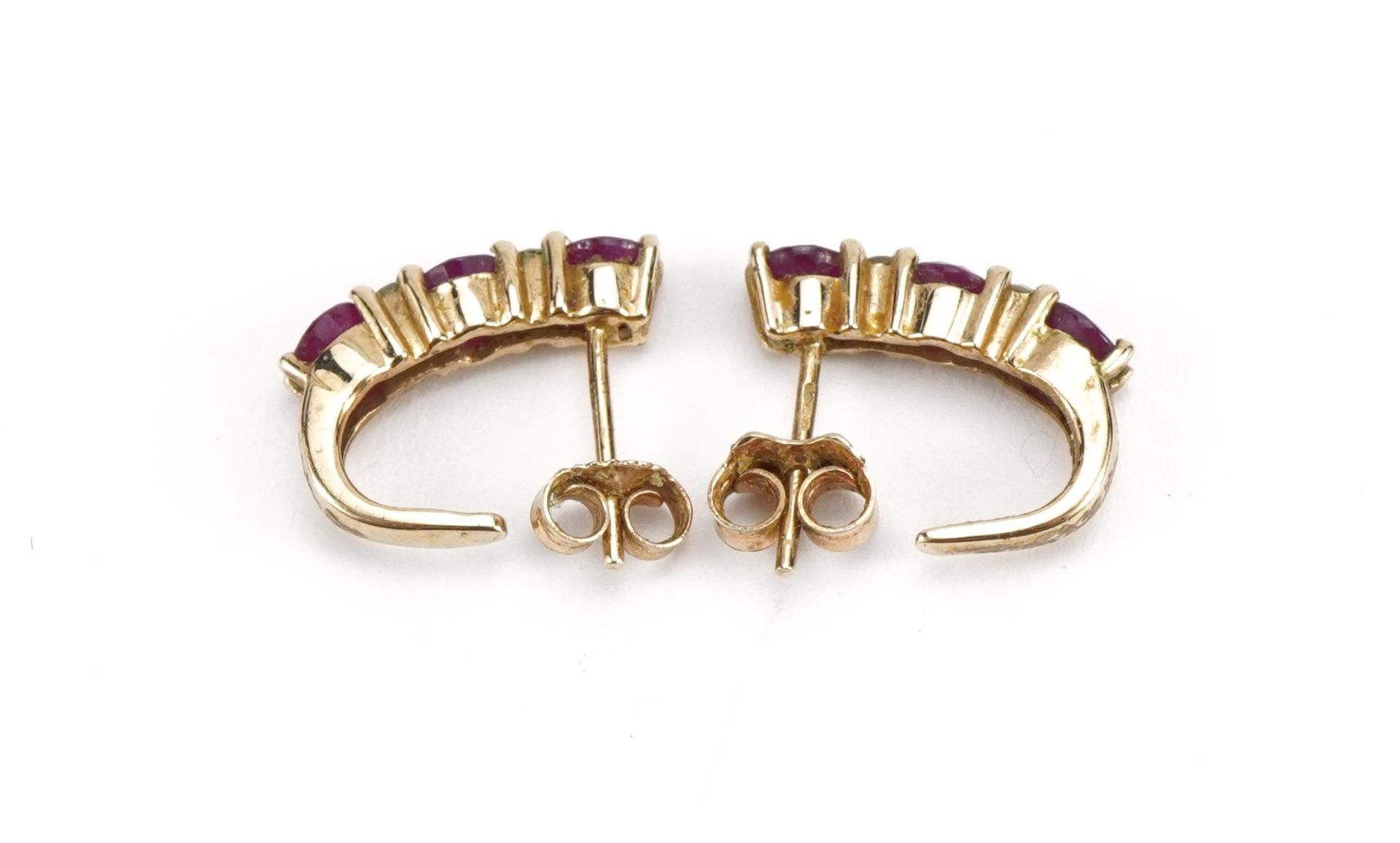 Pair of 9ct gold ruby and clear stone, half hoop stud earrings, the clear stones test as sapphire, - Image 2 of 2