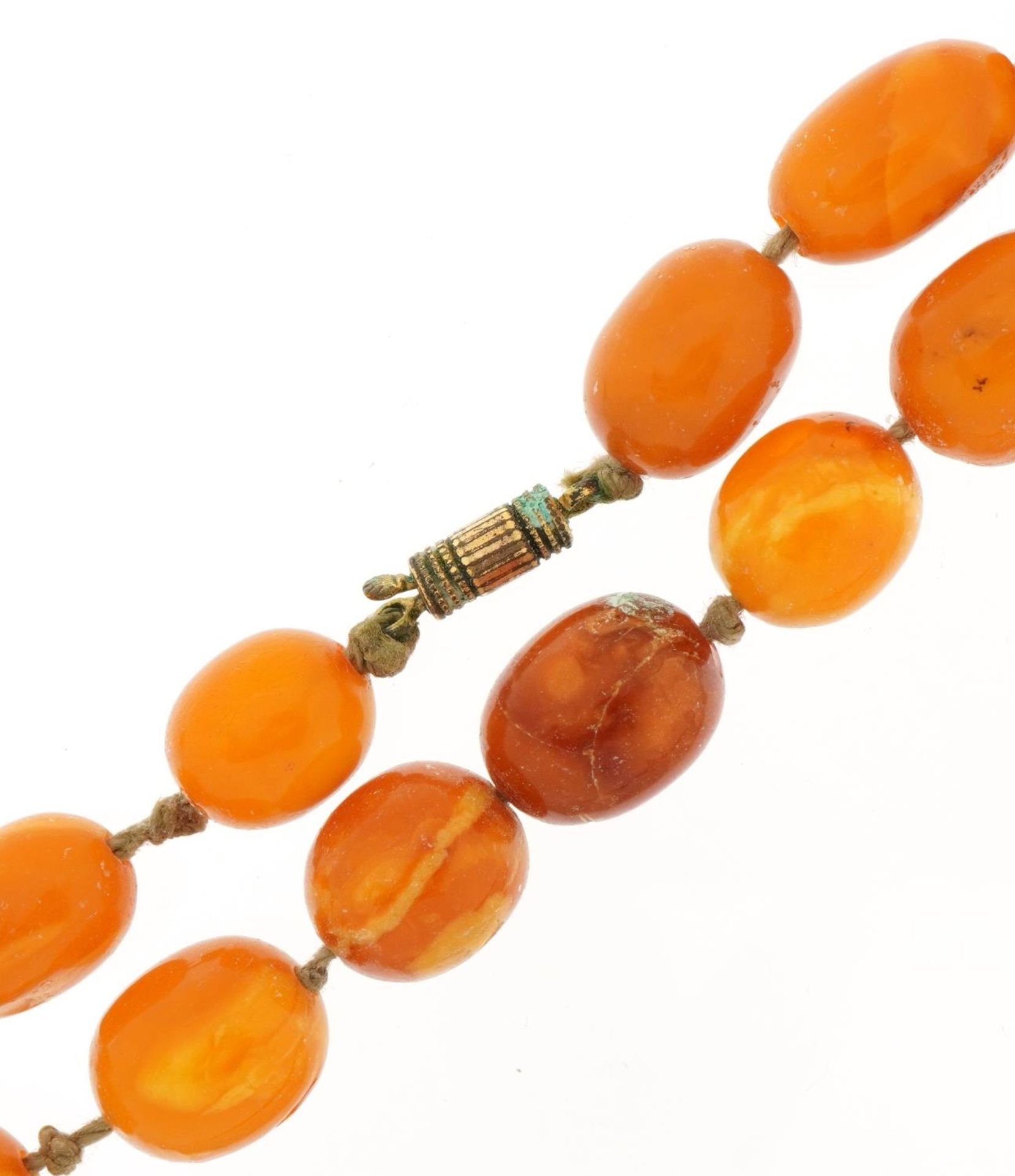 Butterscotch amber coloured graduated bead necklace, the largest bead 1.7cm in length, 54cm in