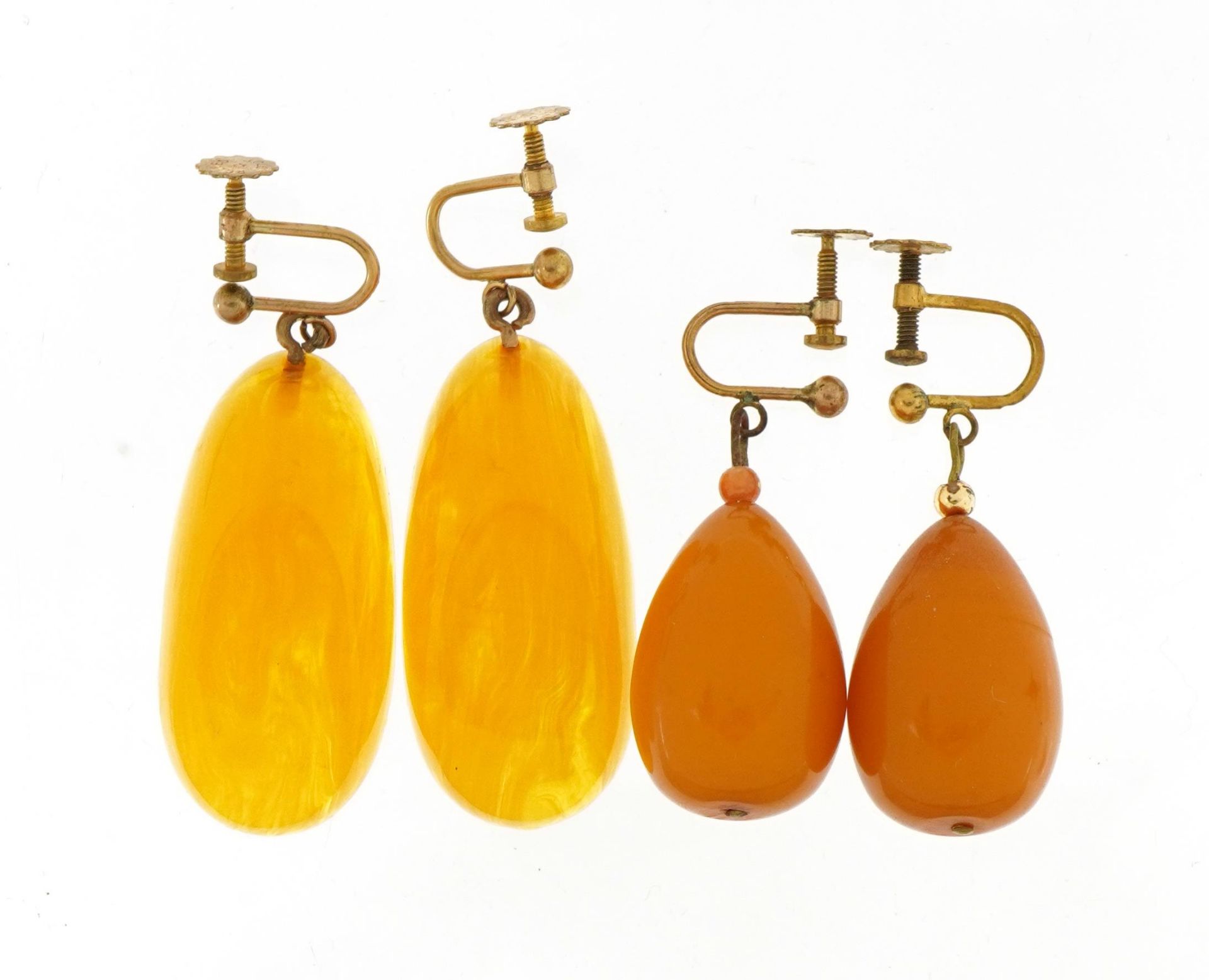 Two pairs of butterscotch amber coloured drop earrings with rolled gold screw backs, the largest 4.