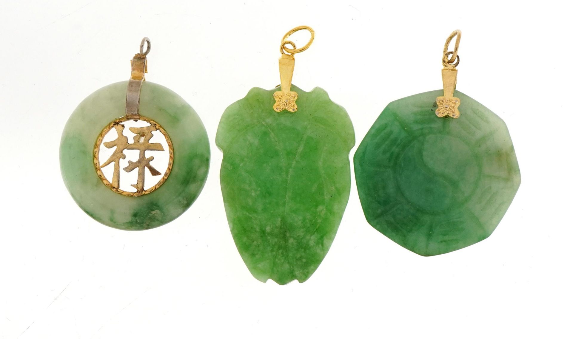 Three Chinese green jade pendants with yellow metal mounts, the largest 4cm high, total weight 20.6g