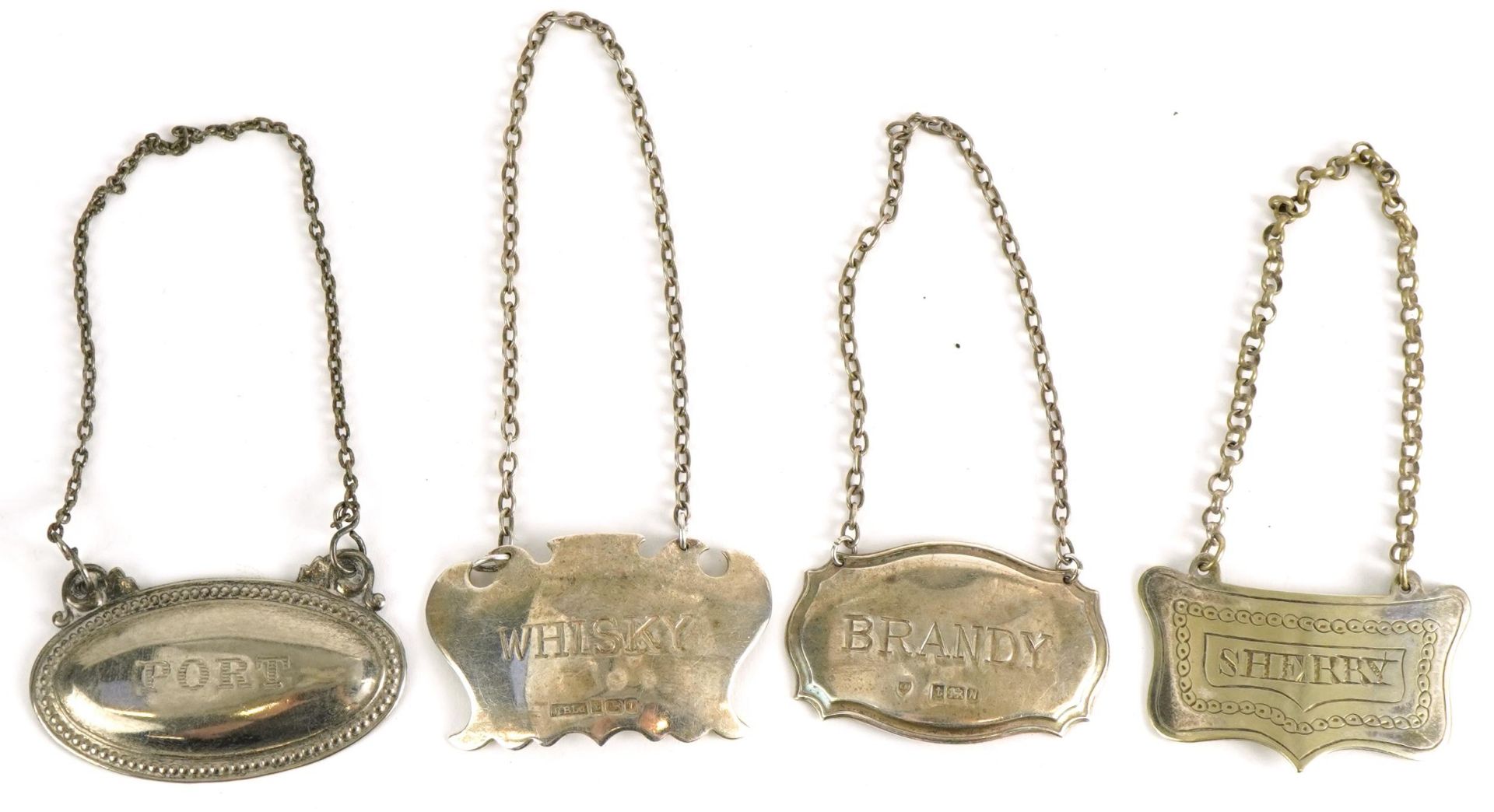 Four decanter labels including two silver examples, comprising whisky, brandy, sherry and port,