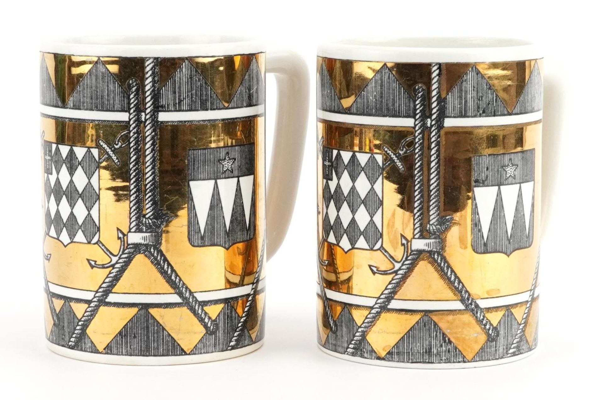 Fornasetti, pair of vintage Italian gold lustre mugs decorated with shields, each 12.5cm high :