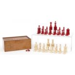 Half stained carved bone chess set with mahogany case having sliding lid, the largest pieces each