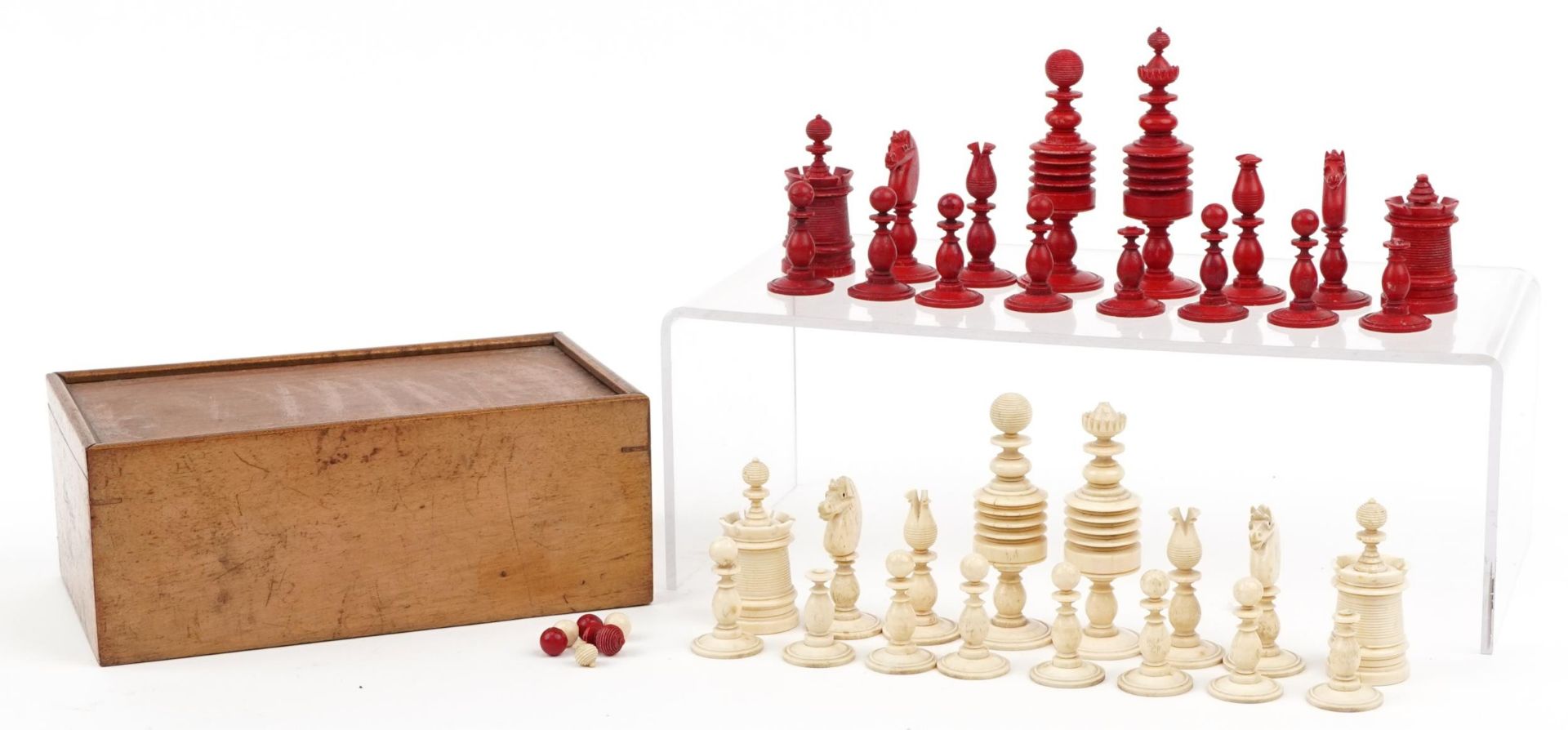 Half stained carved bone chess set with mahogany case having sliding lid, the largest pieces each