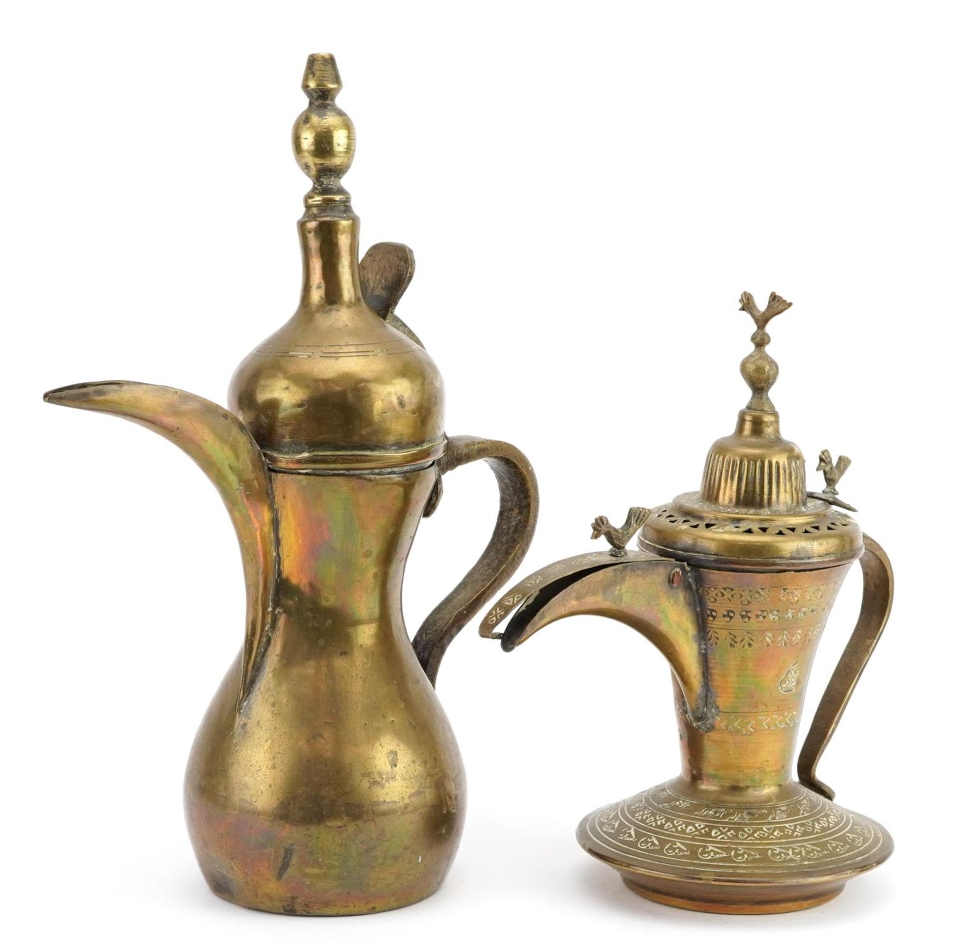 Two Omani brass dallah coffee pots including one with impressed decoration, the largest 31cm