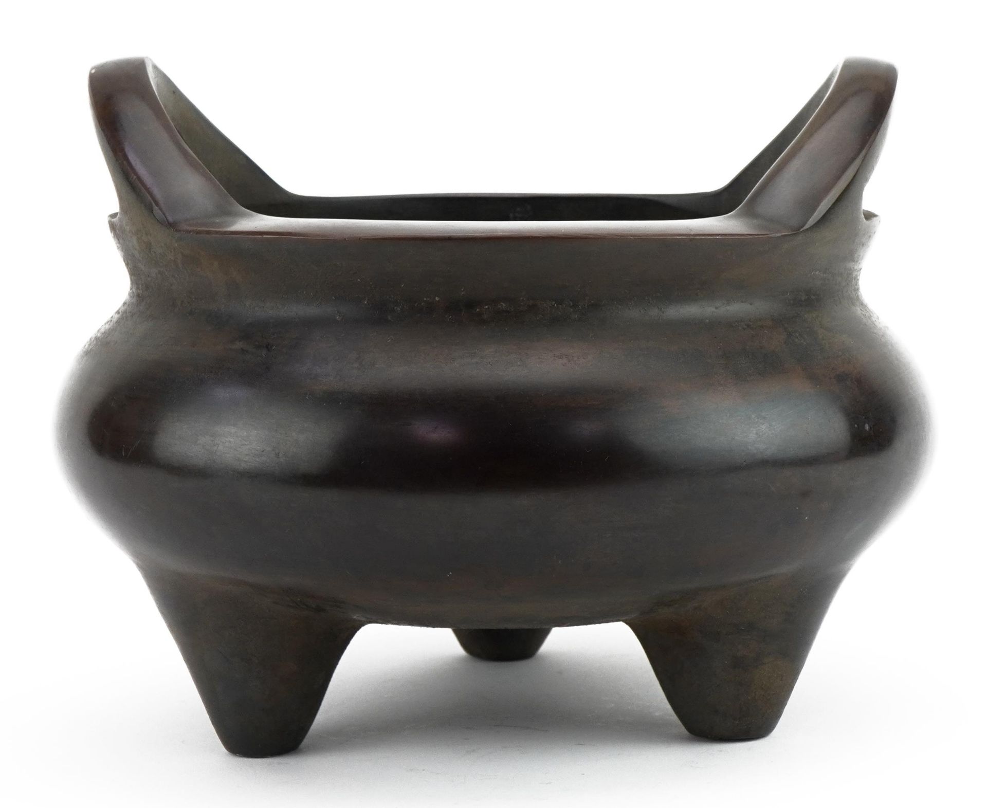 Large Chinese patinated bronze tripod censer with twin handles, four figure character marks to the