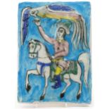 Persian pottery tile hand painted and decorated in low relief with figure on horseback feeding a