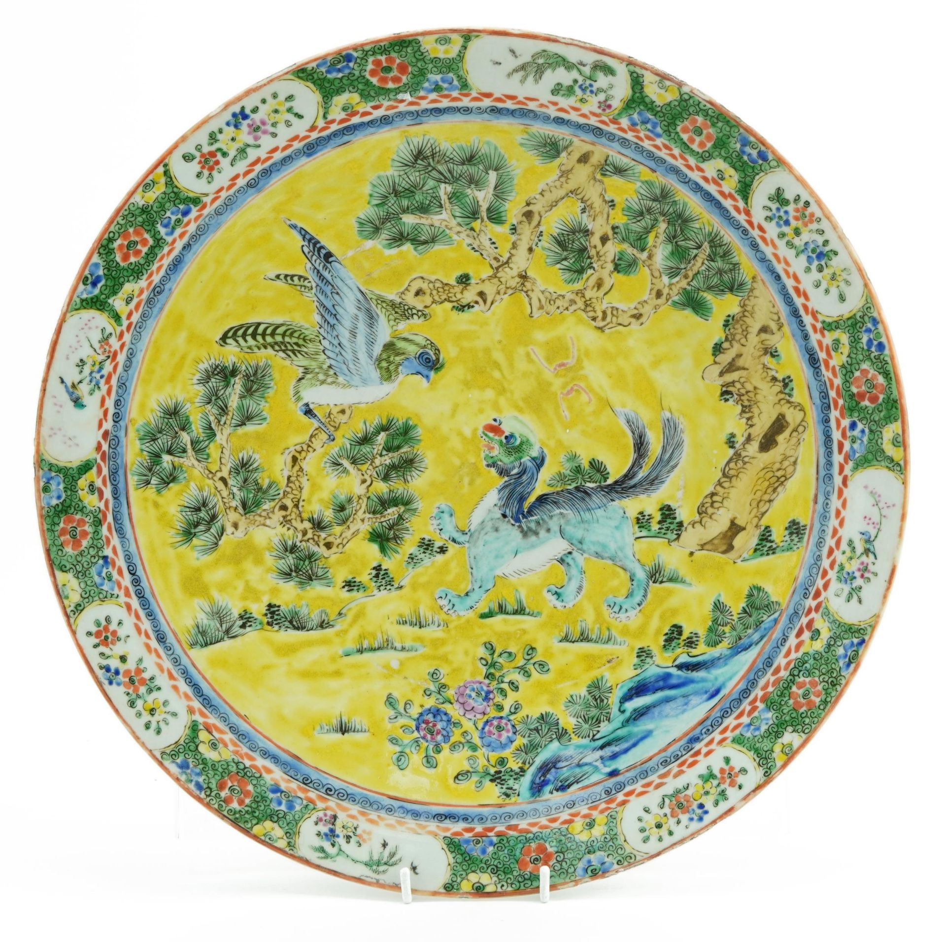 Chinese porcelain yellow ground charger hand painted in the famille verte palette with a mythical