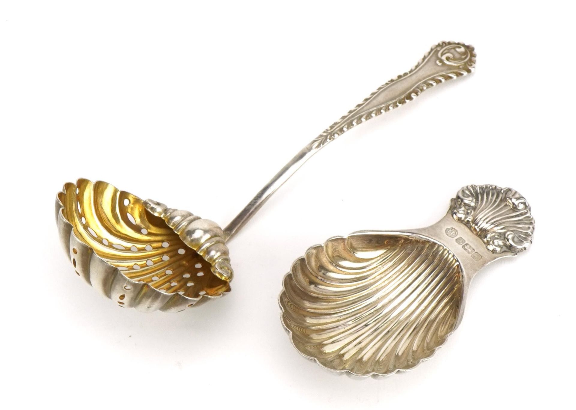 Edwardian silver tea strainer with gilt interior and an Elizabeth II silver caddy spoon with shell