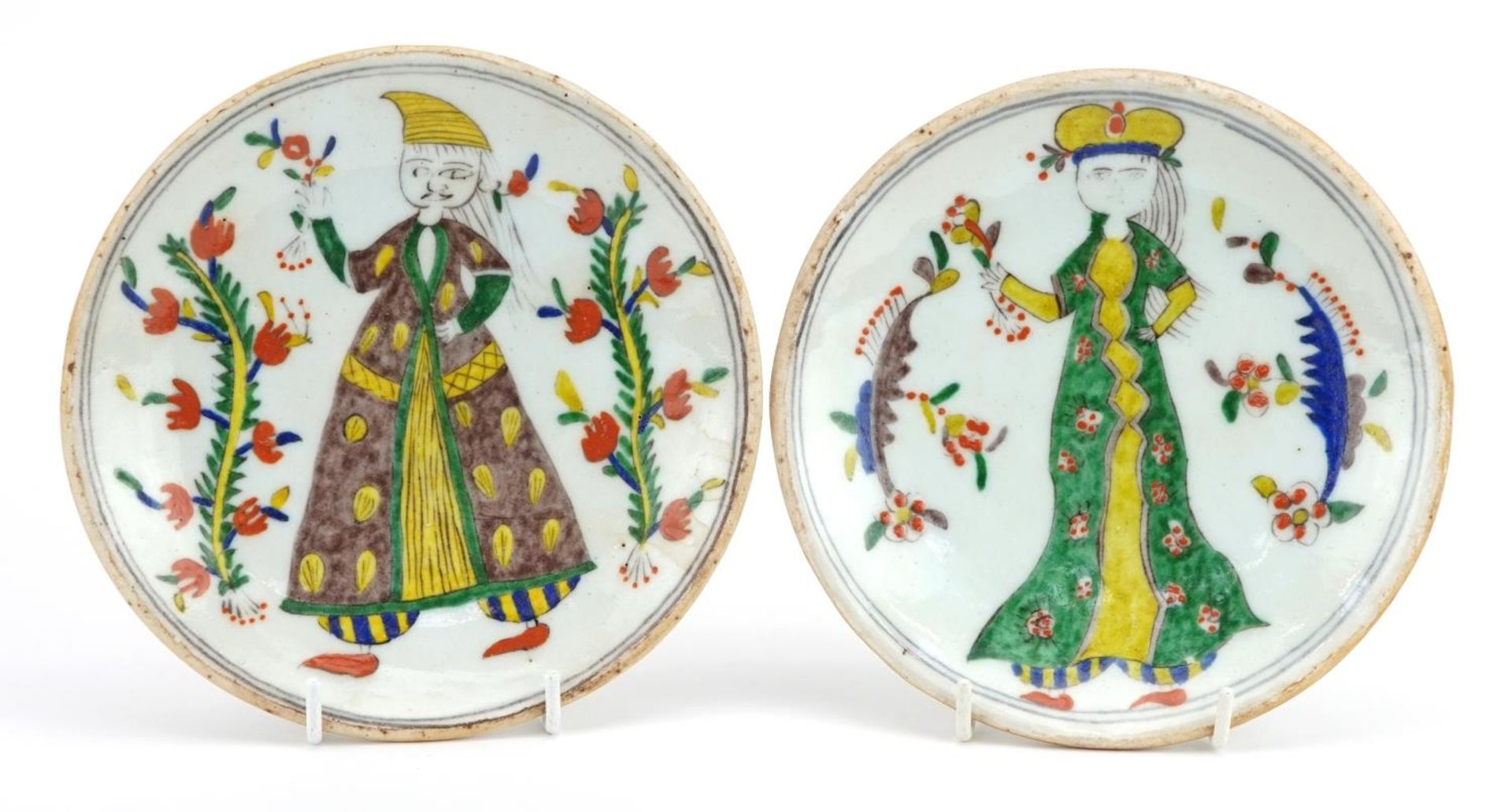 Pair of Turkish Ottoman Kutahya pottery dishes hand painted with figures wearing traditional dress