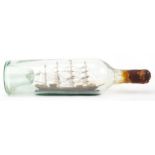 Early 20th century glass ship in a bottle housing a wooden model of a frigate, 34cm high : For