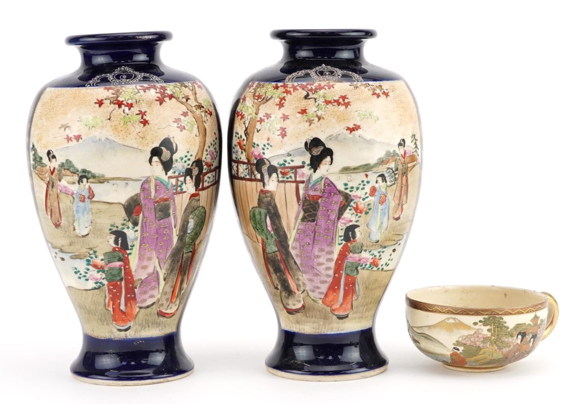 Pair of Japanese Satsuma pottery vases and a cup hand painted with figures in a landscape, the vases