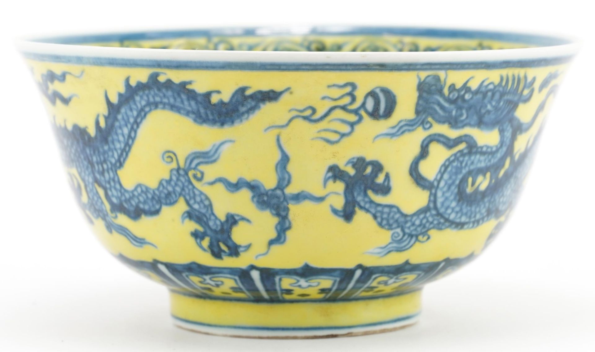 Chinese porcelain yellow ground bowl hand painted with dragons chasing the flaming pearl, six figure