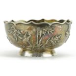 Chinese export silver footed bowl decorated in relief with birds amongst bamboo grove, indistinct
