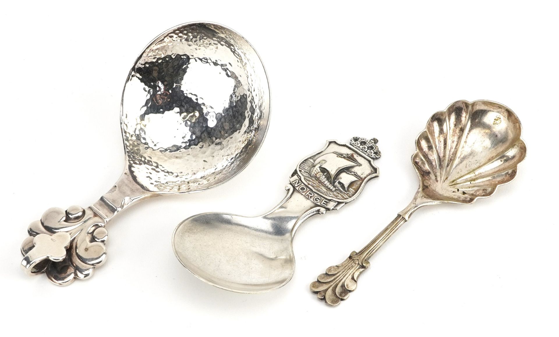 Three decorative arts caddy spoons including one with planished bowl in the style of Georg Jensen,
