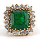 Large 18ct gold emerald and diamond cluster ring housed in a red tooled leather box , the emerald