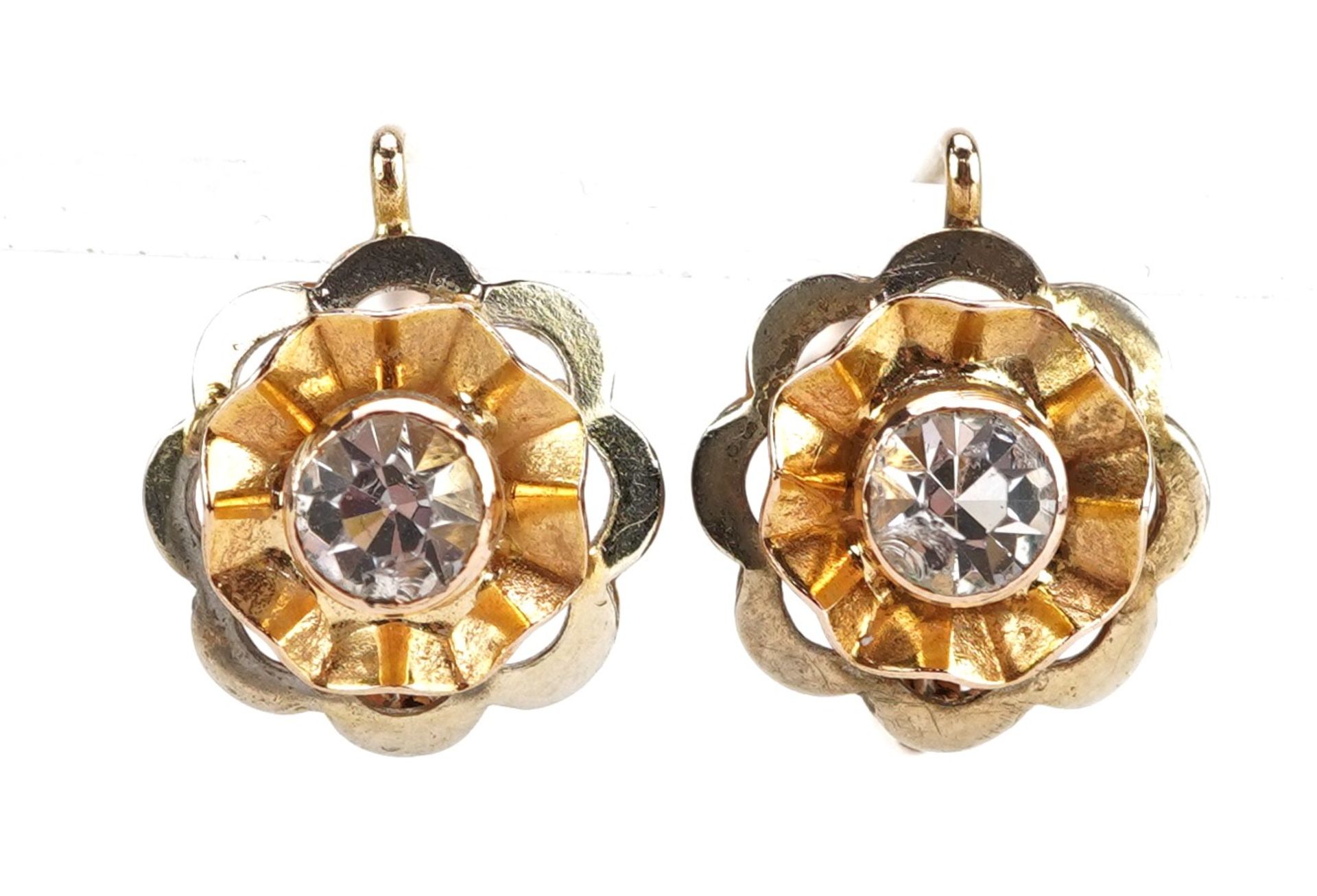 Pair of unmarked gold clear stone flower head earrings, tests as 14ct gold, 1.2cm in diameter, 3.